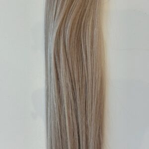 A close-up of Avery—a straight, light brown hair product with subtle highlights—styled in smooth, wavy strands against a plain white background.