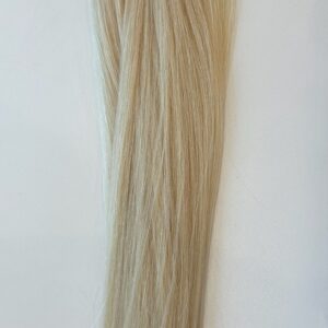 A long strand of straight, light blonde Frannie hair lies against a plain white background.