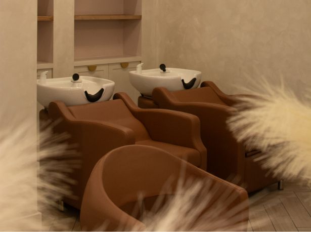 A chic salon interior featuring two elegant sinks and a stylish chair, showcasing Luxe Hair Artists' sophisticated ambiance.