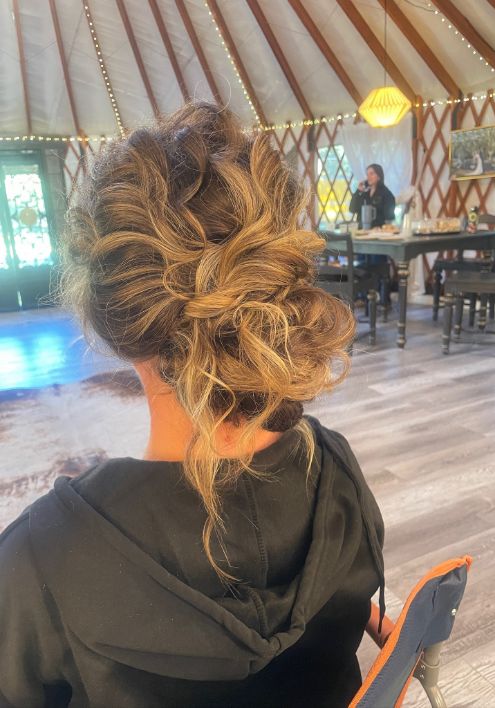 A woman with elegant hair poses gracefully inside a luxurious yurt, showcasing the refined ambiance of Luxe by The Gallery.